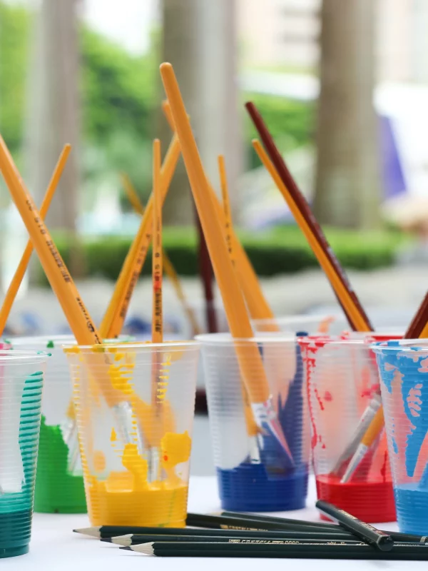 Pots de peinture avec pinceaux colorés.
