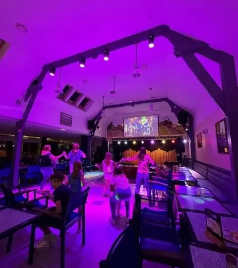 Enfants dansent dans une salle colorée.