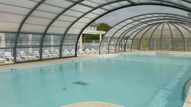Piscine intérieure avec chaises longues à disposition.