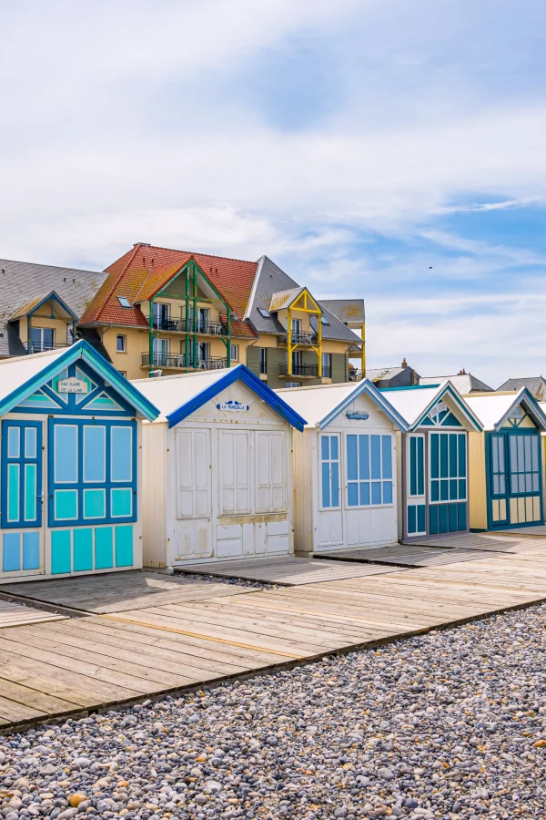 Cabines de plage colorées alignées sur le bord de mer.