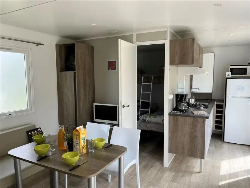Intérieur d'un mobile home avec cuisine et salle à manger.