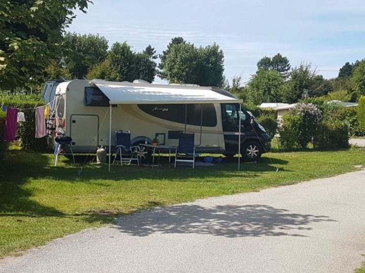 Camping-car stationné sur un terrain verdoyant.