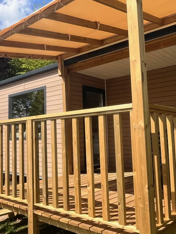 Mobil-home avec terrasses en bois et fenêtres.
