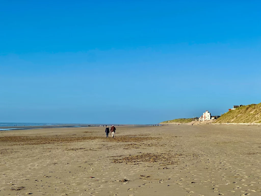 Twee mensen wandelen op een verlaten strand