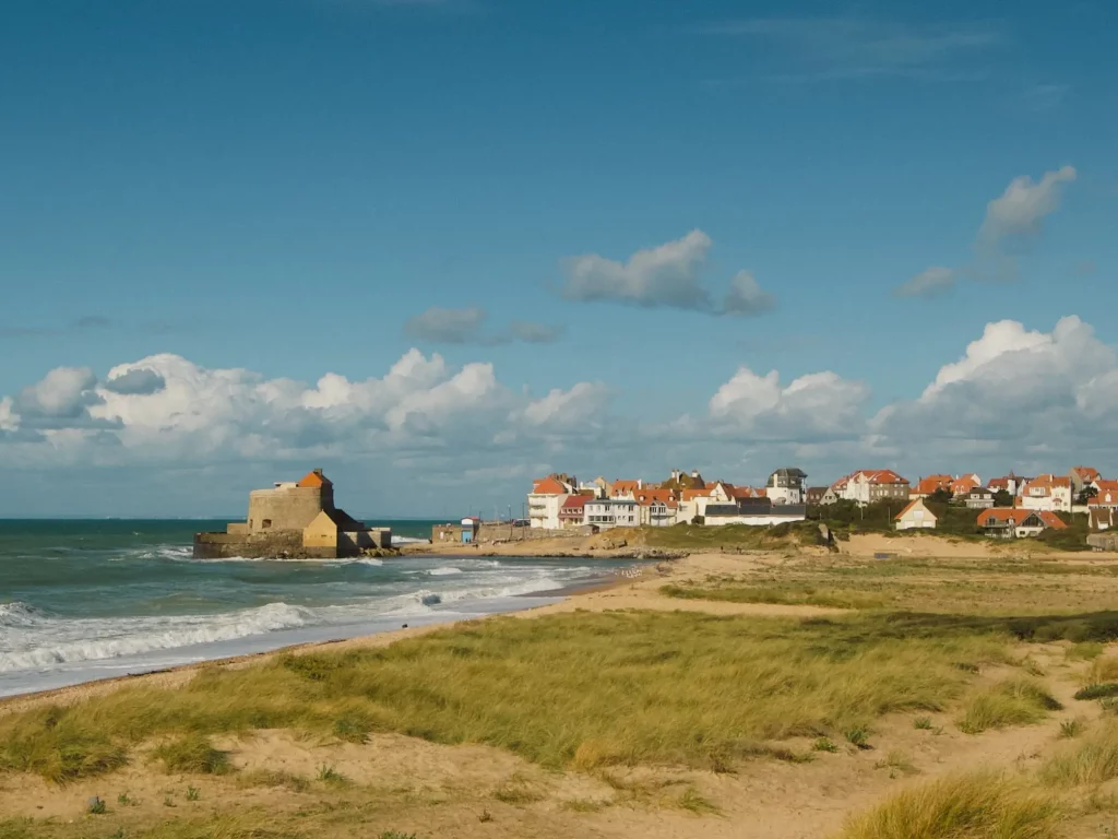 Plage avec maisons et nuages en arrière-plan