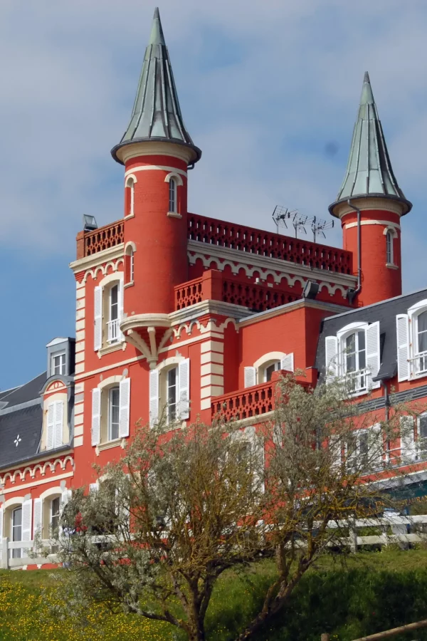 Maison historique avec tours, peinture rouge éclatante.