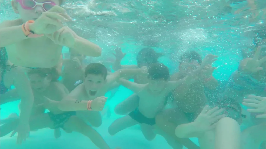 Enfants jouant dans une piscine sous l'eau.