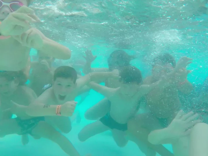 Enfants jouant dans une piscine sous l'eau.
