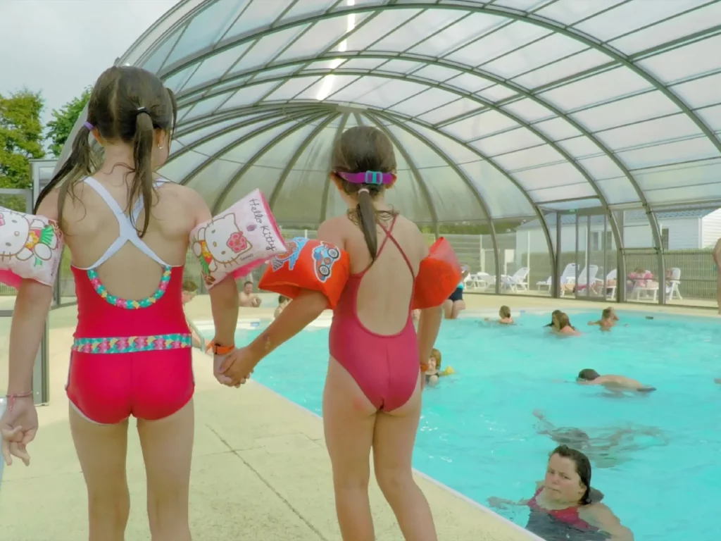 Deux enfants marchant vers la piscine.