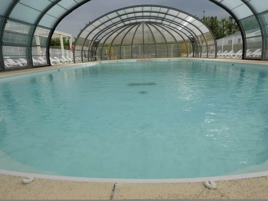 Piscine couverte avec eau turquoise paisible.