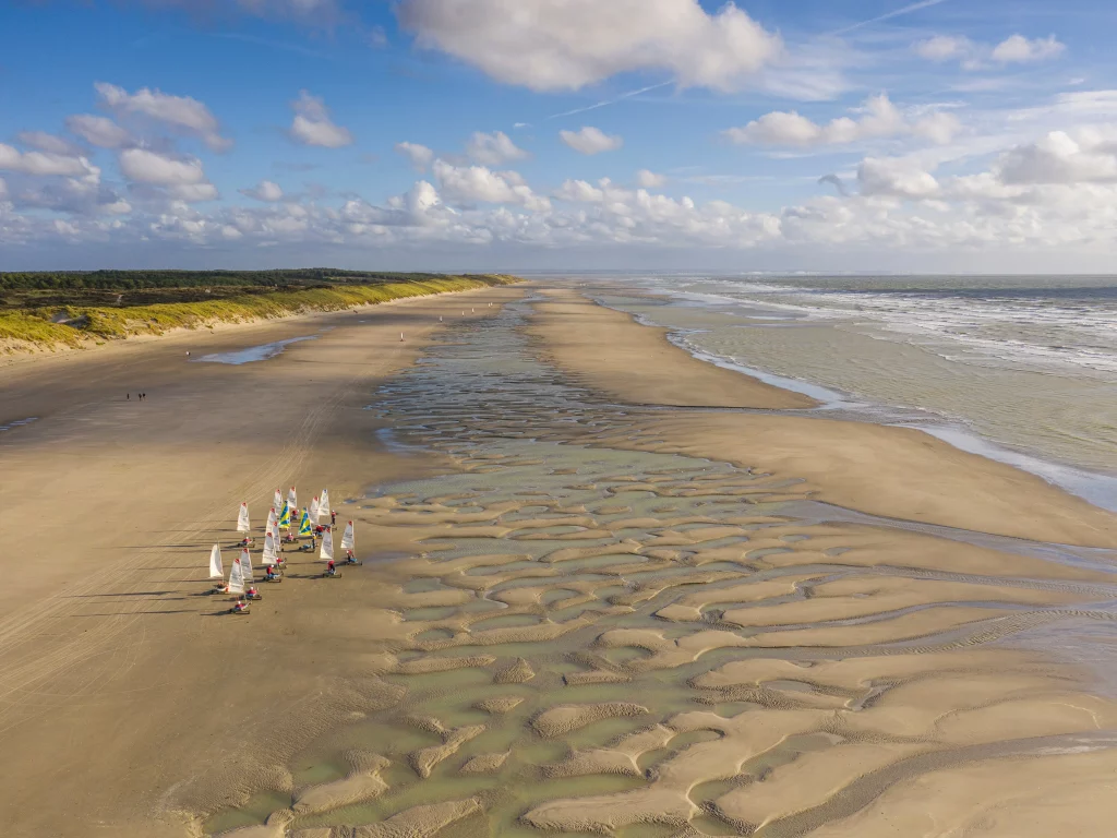 Plage avec voiliers et paysages marins apaisants.