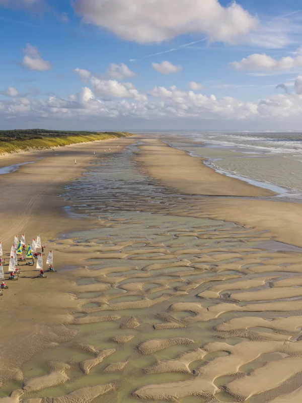 Plage avec voiliers et paysages marins apaisants.