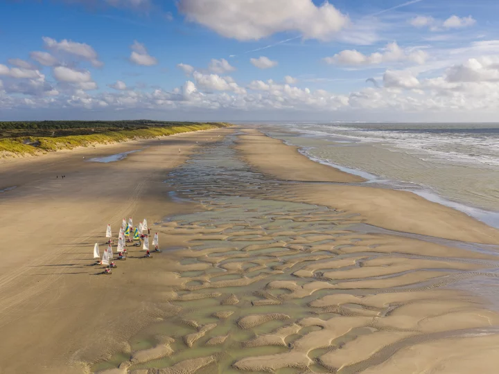 Plage avec voiliers et paysages marins apaisants.