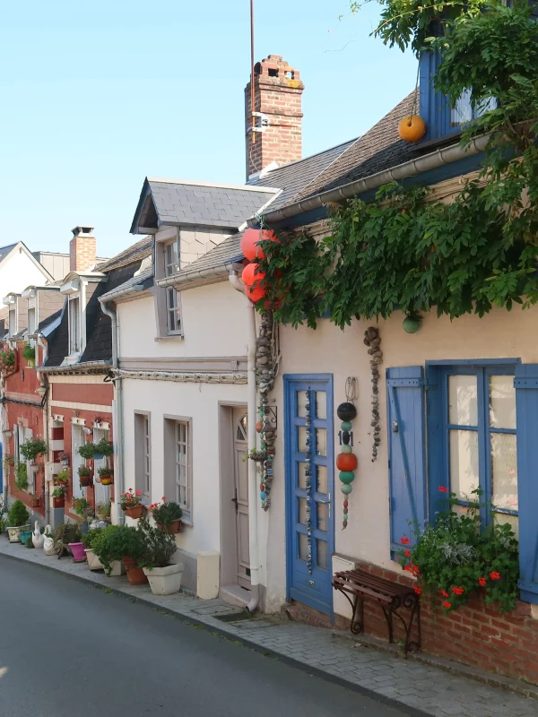 Rue pittoresque avec maisons colorées et fleurs.