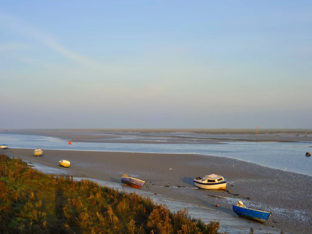 Des bateaux sur une plage au coucher du soleil