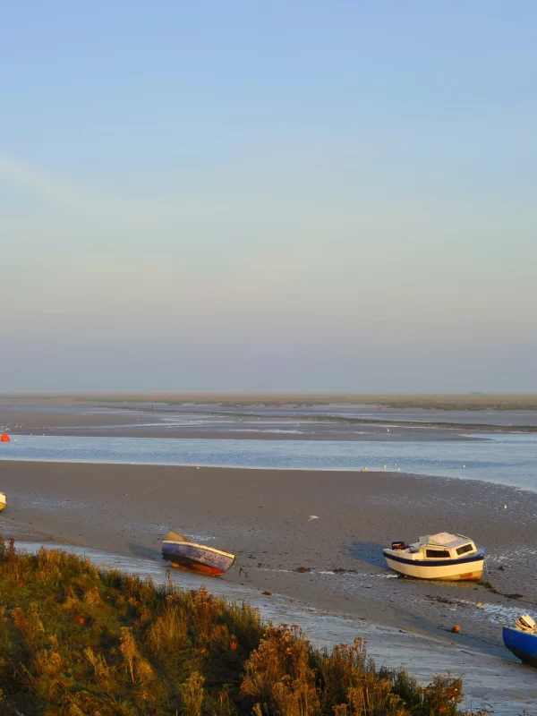 Des bateaux sur une plage au coucher du soleil