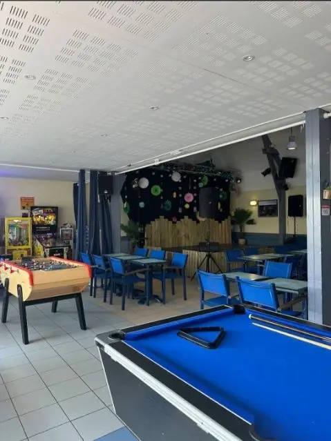 Intérieur d'un café avec tables et jeux.