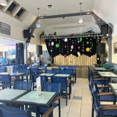 Intérieur d'un café avec scène et tables.