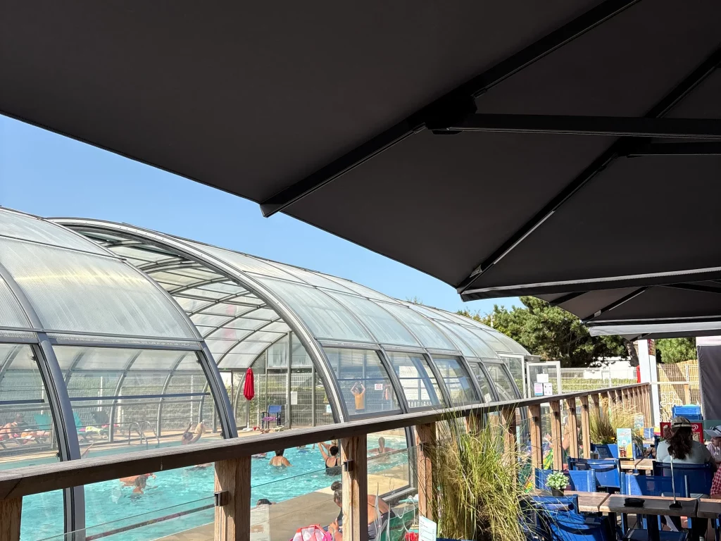 Terrasse avec vue sur piscine couverte animée.