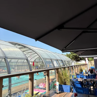 Terrasse avec vue sur piscine couverte animée.