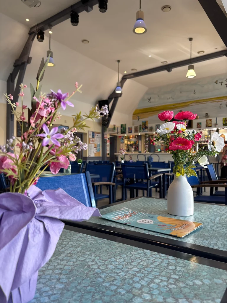 Fleurs colorées dans un café lumineux et accueillant.