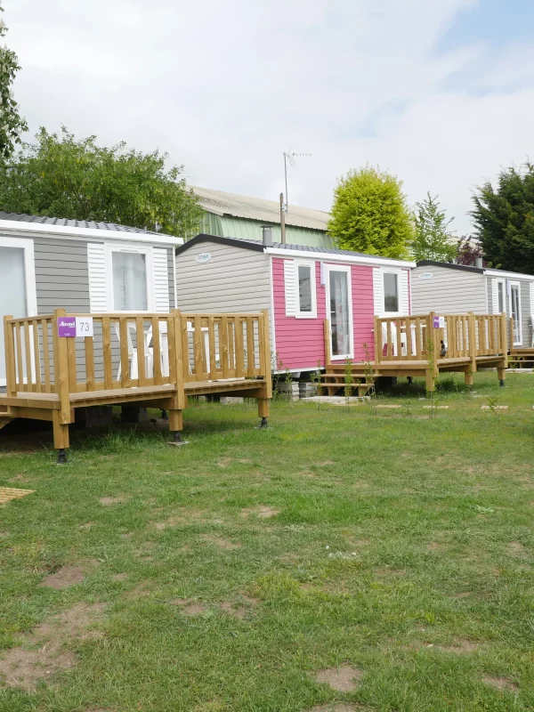 Mobil-homes colorés dans un espace verdoyant.