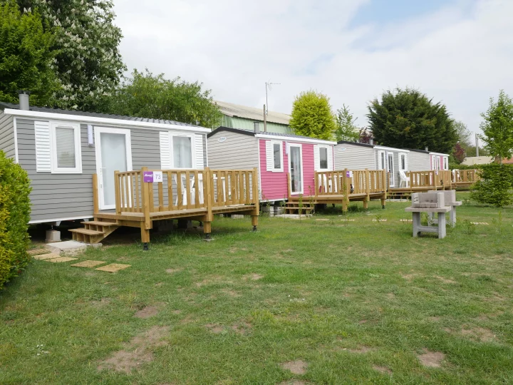 Mobil-homes colorés dans un espace verdoyant.
