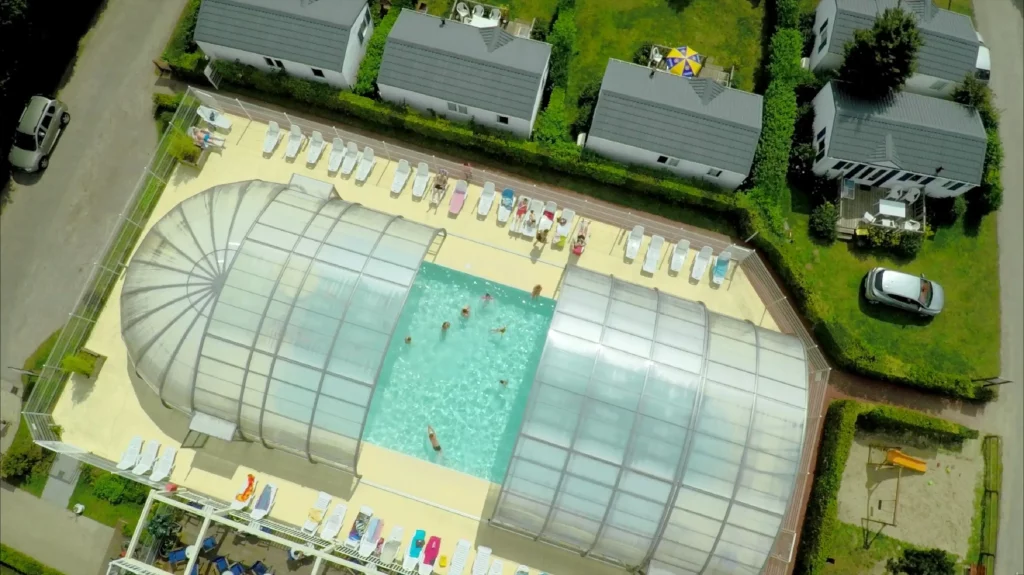 Vue aérienne d'une piscine intérieure avec transats.
